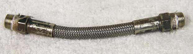 4.5” steel braided hose, used shape, wrench marks on ends, spray painted on ends