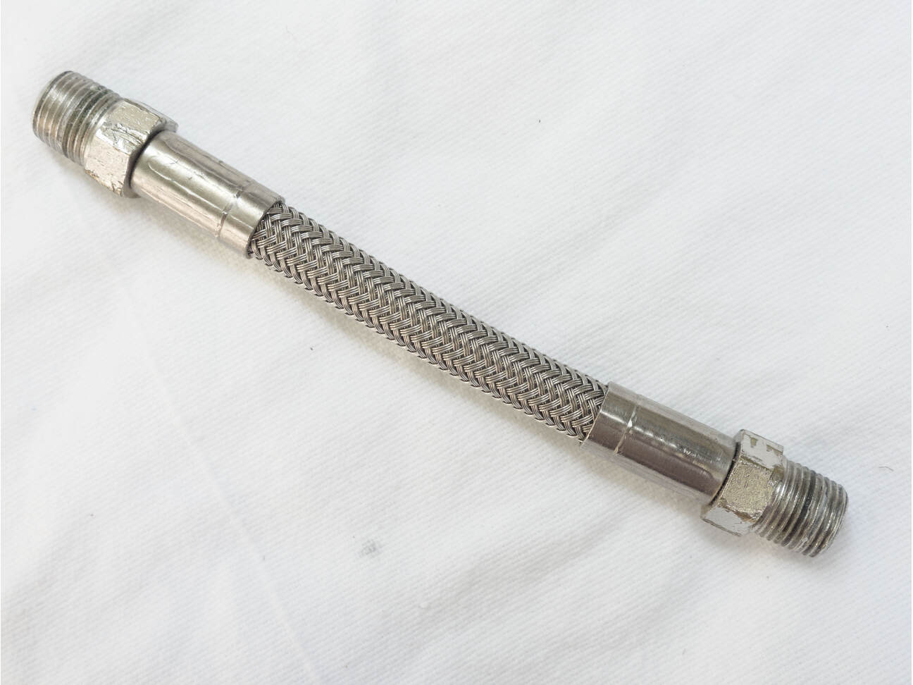4.5” steel braided hose, used shape, wrench marks on ends
