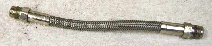 5.75” steel braided hose, used shape, has wrench marks