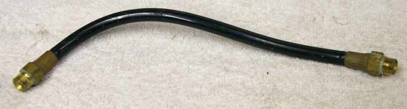 Old 9.5” black plastic hose, 2500psi rated would not recommend over 800 psi, used decent shape, brass ends, has bend