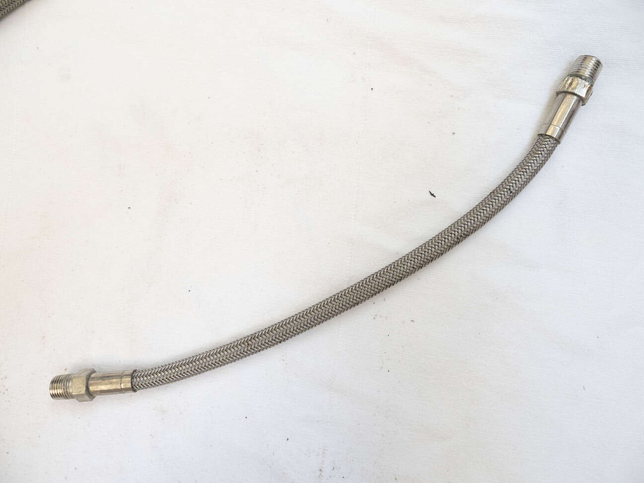 9.75” steel braided hose, used shape with lots of wrench marks