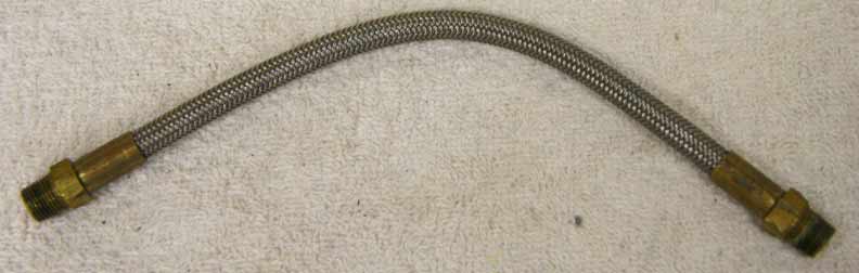 8.75” steel braided hose with brass ends in used decent shape, has wrench marks on ends