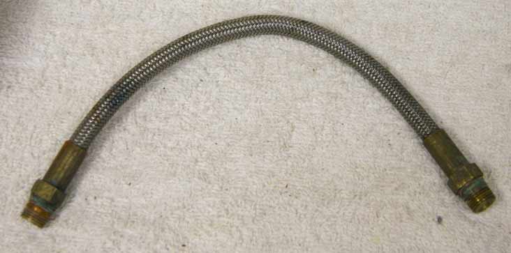 8.75” steel braided hose with brass ends in used decent shape, dirty