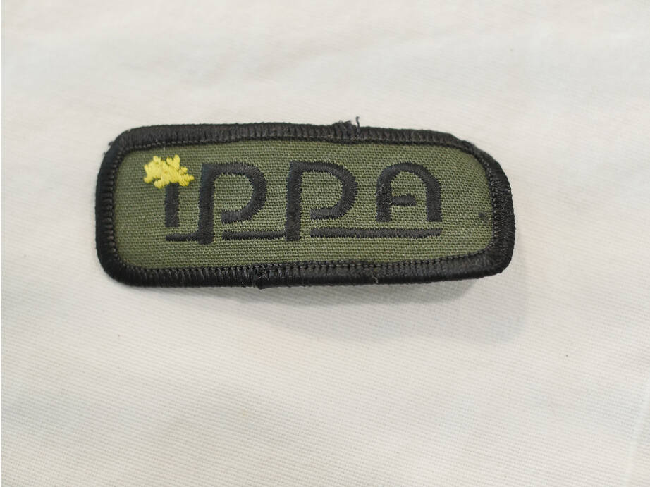 IPPA patch, looks good, with iron on still on back but surface worn. Yellow splat.