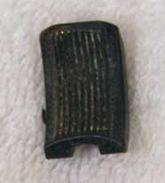 grooved brass trigger shoe, used shape, dirty and blacked and tarnished